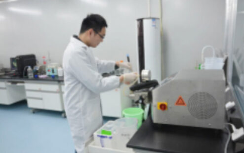 Researcher operating equipment at a laboratory bench